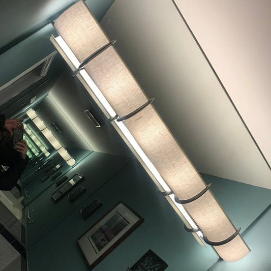 This is a white linen shade with 4 silver brackets over a beveled edge light. Usually on a beveled edge we can hide the bulbs but not the bottom of the fixture.