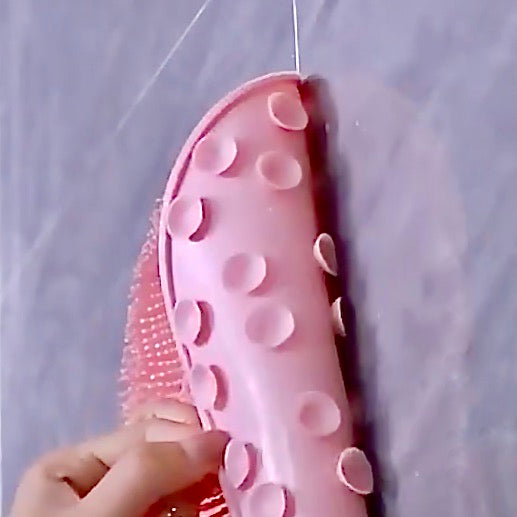 Pink bath scrubber showing the suction cup backing